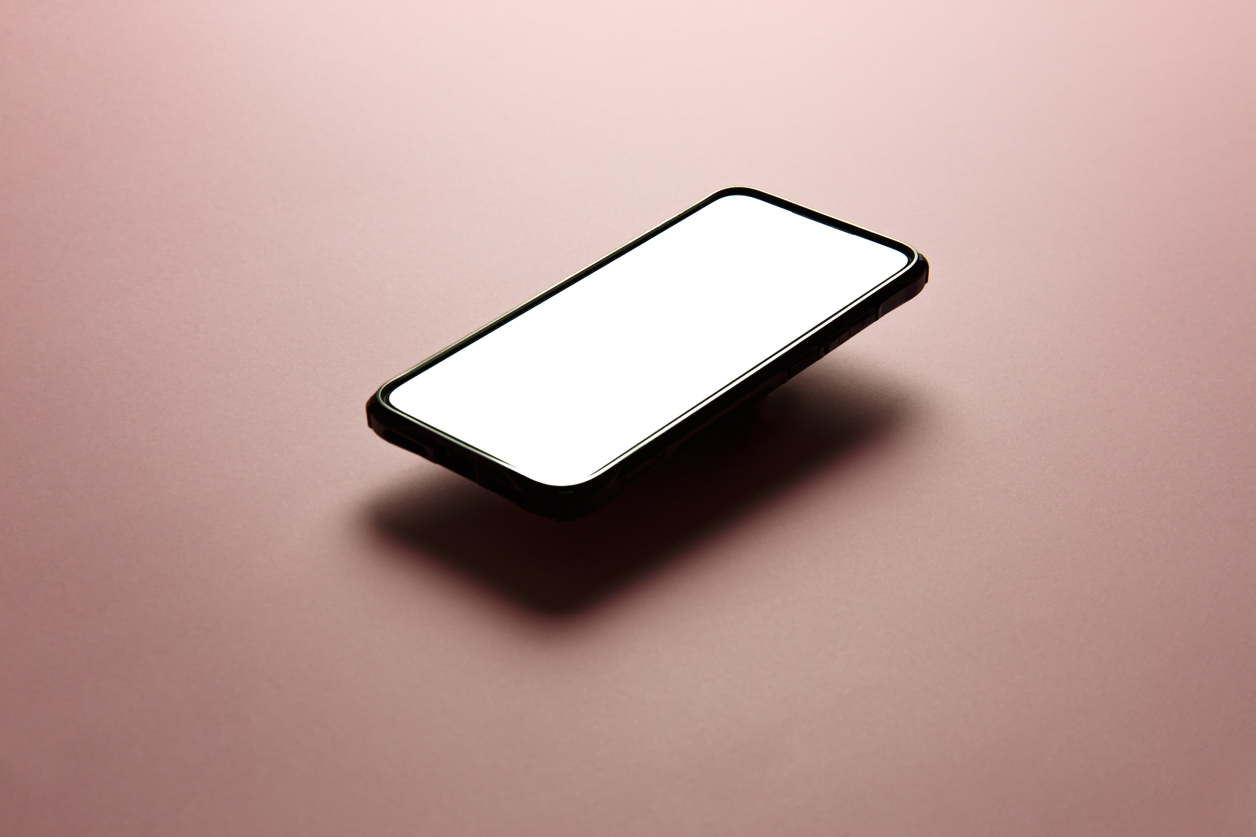 black-cellphone-floats-above-pink-background.jpg